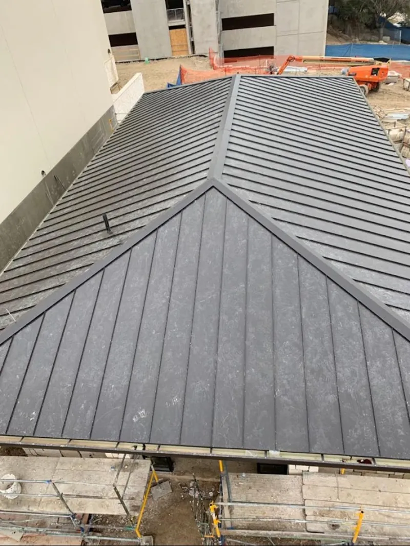 Commercial metal roof construction with crane equipment in Cherry Creek